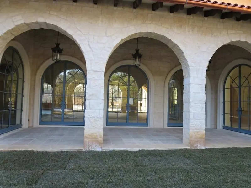 Limestone arcade of arched openings with hanging lanterns on a Mediterranean-style home