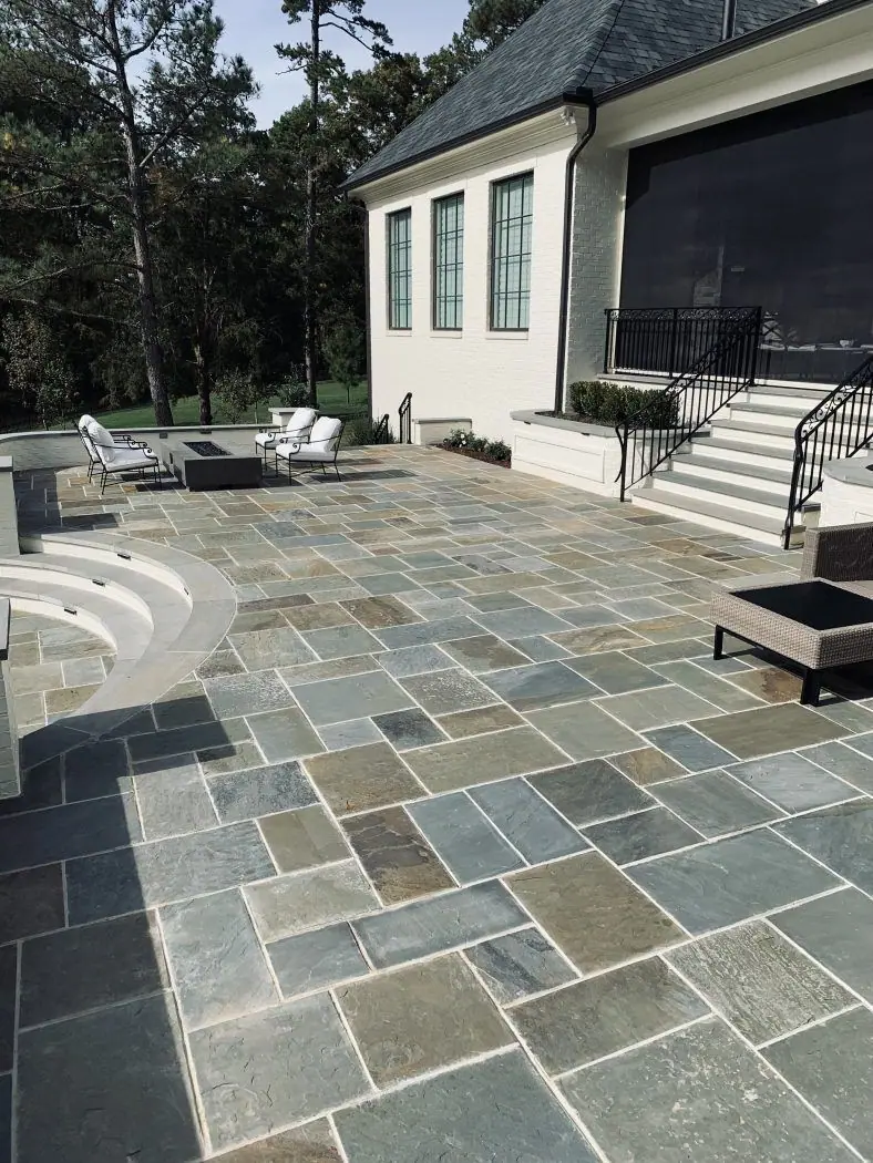 Multicolor bluestone patio with a curved seat step and fire pit at a modern house