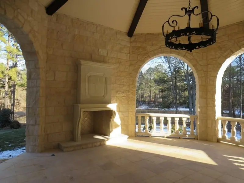 Limestone pavilion with arched openings and a carved stone fireplace