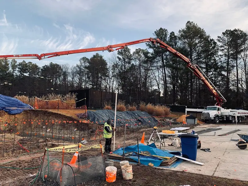 Concrete pump truck placing a footing pour on a large building site