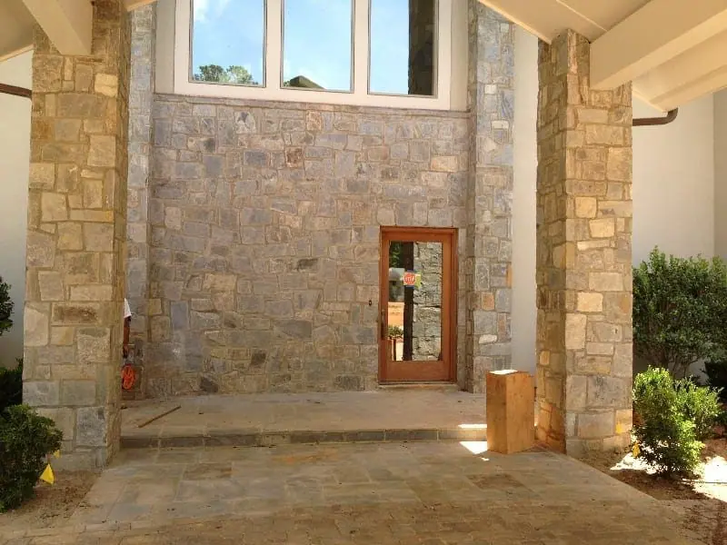 Two-story natural stone entry wall with stone piers