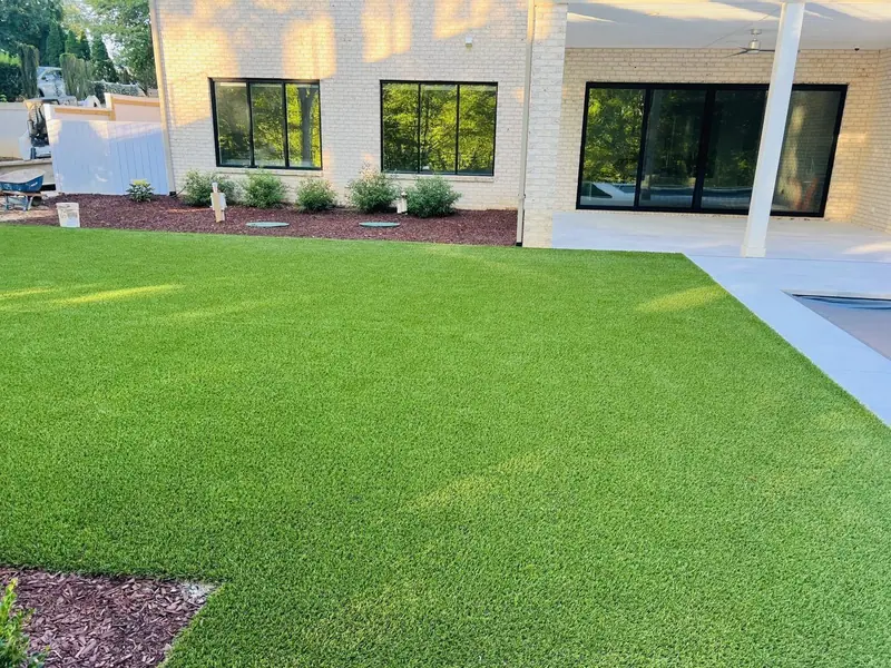 Artificial turf lawn in front of a modern white brick house
